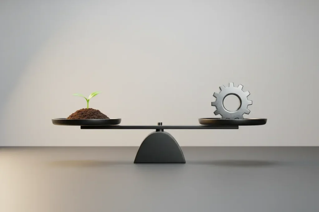 Balance scale weighing a green sprout against a polished steel gear on a soft gray background.